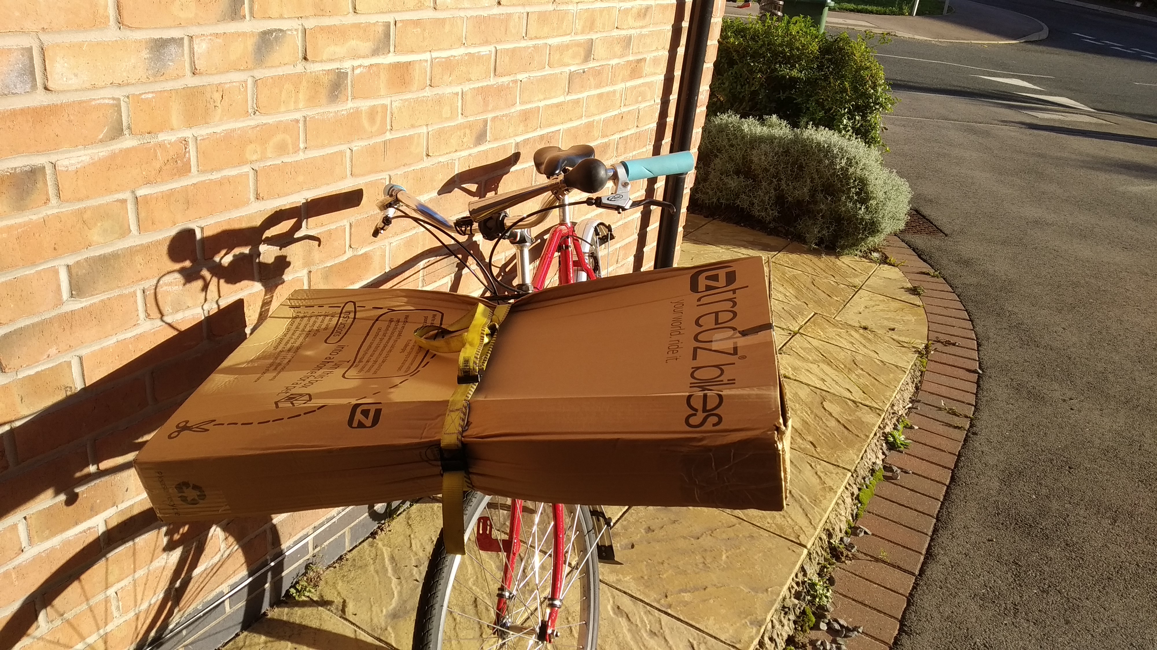 My Postie bike with a large box strapped with a yellow truck tie