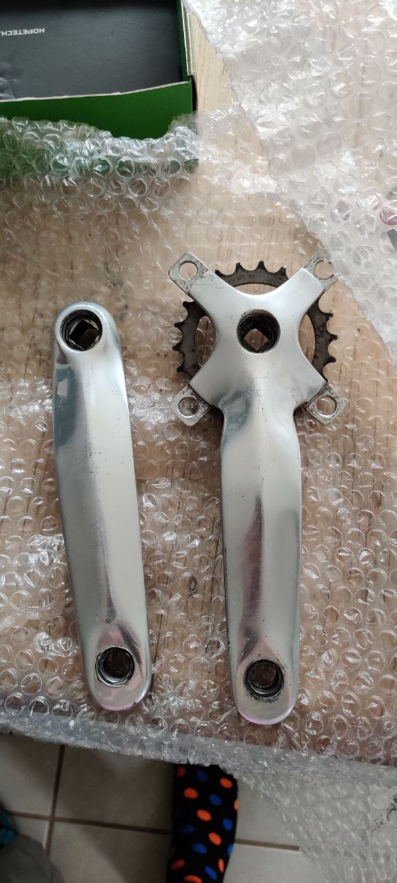A pair of silver, square taper cranks on a desk