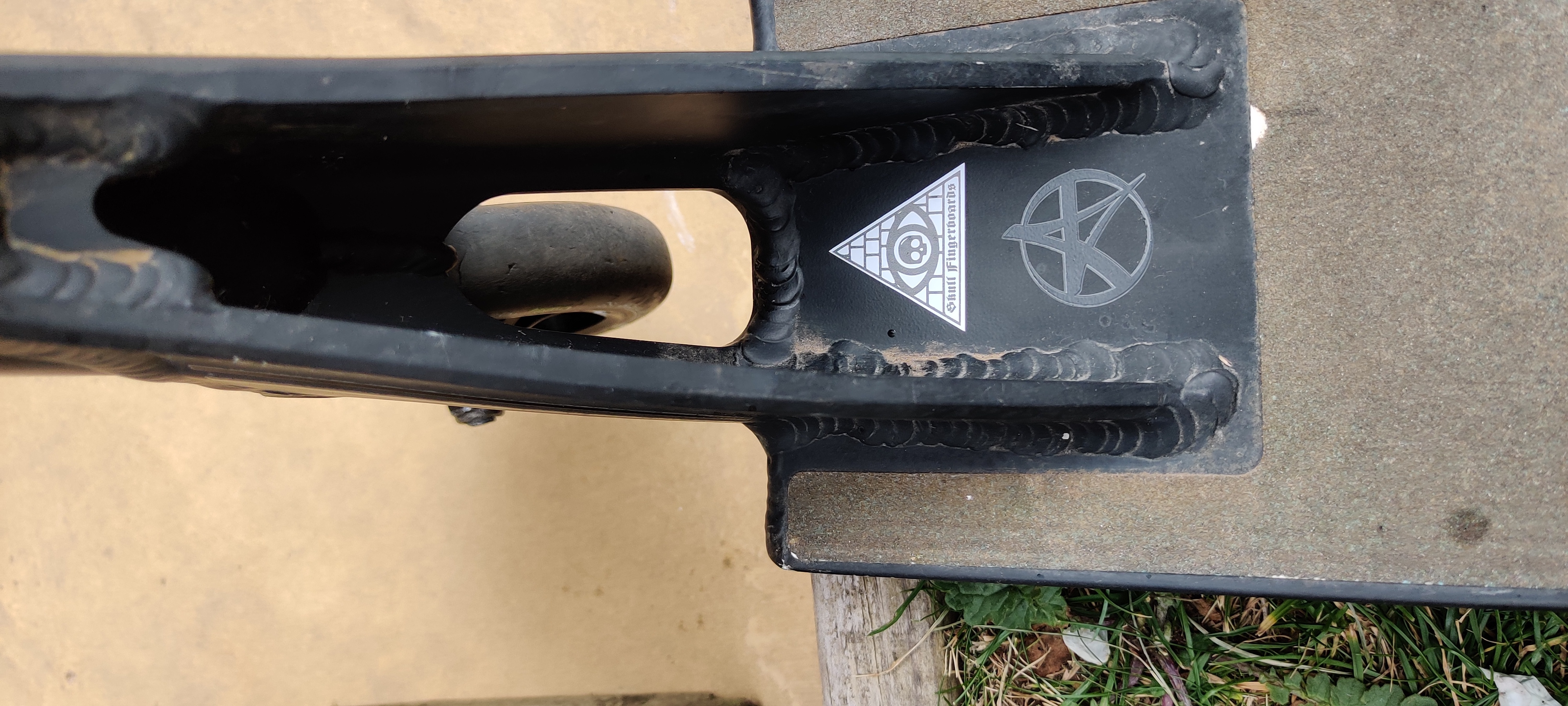 Close up of the Skull Fingerboards pyramid sticker that's inside the deck head tube.