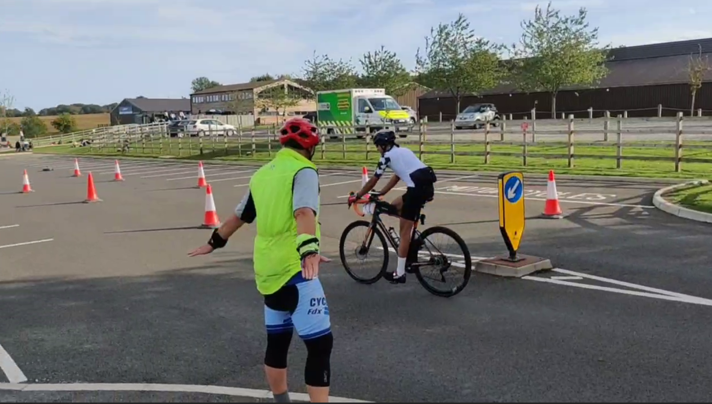 Dharms in a white jersey on his bike after crossing the line, being clapped in by Dad, and filmed by me