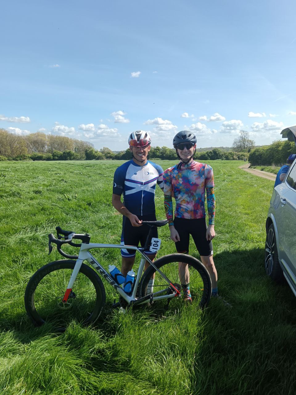 A rider in Scotland kit next to me in a floral shirt. Both smiling, he's holding the broken bike of #104