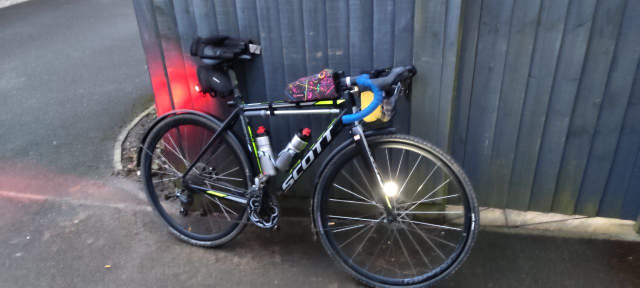 The same bike from the start, in dusk, facing in towards the shed much muddier having now finished the ride