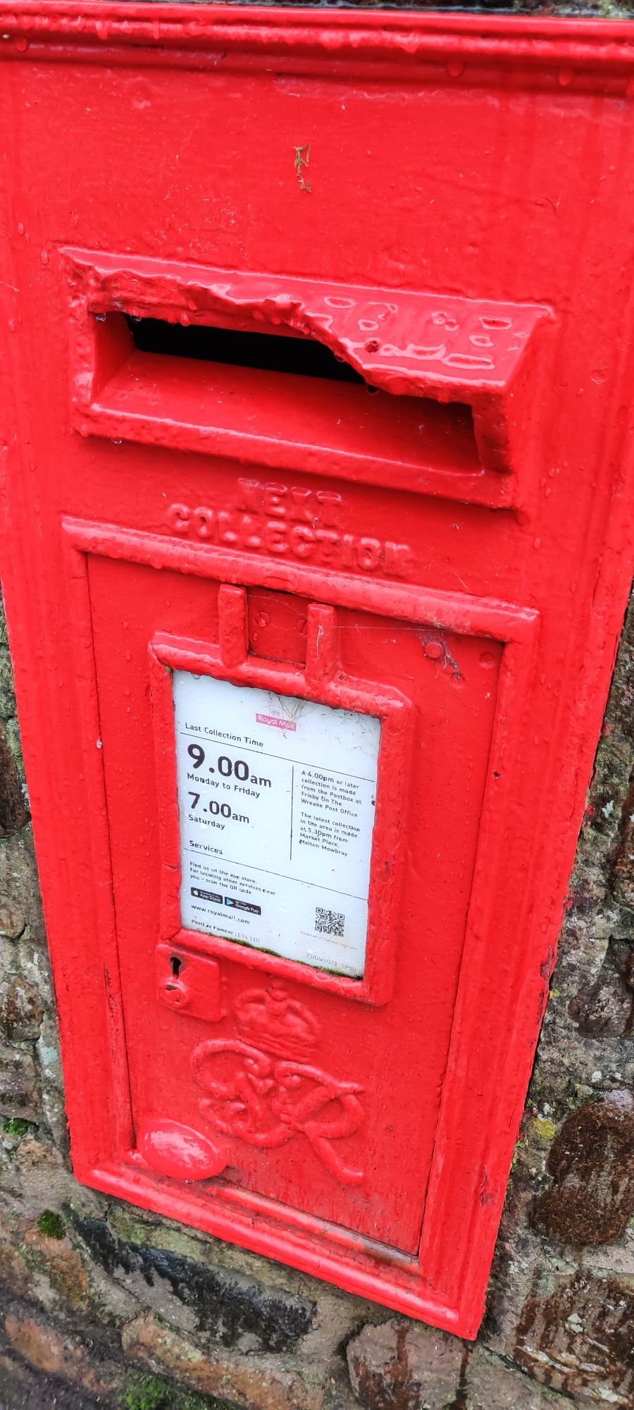 A red postbox embeded in a wall with a Satuday 7am collection time